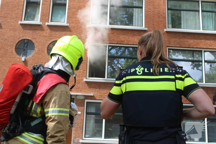 Veel rookontwikkeling vanwege brand in portiekwoning
