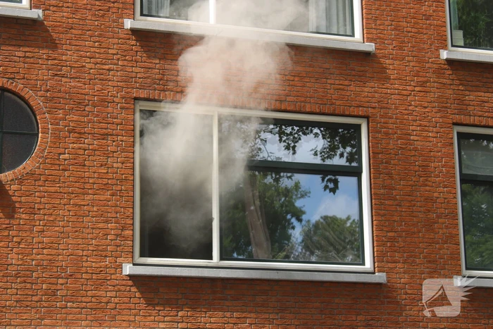 Veel rookontwikkeling vanwege brand in portiekwoning