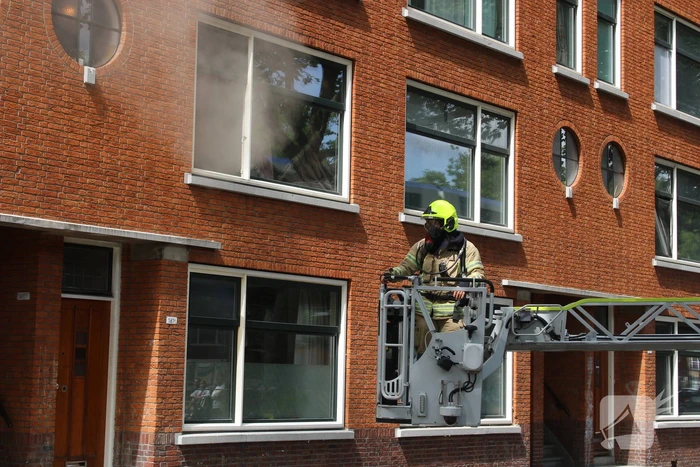 Veel rookontwikkeling vanwege brand in portiekwoning