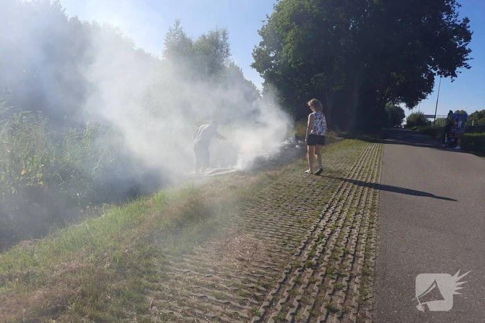 Omstanders doven bermbrand met kleed