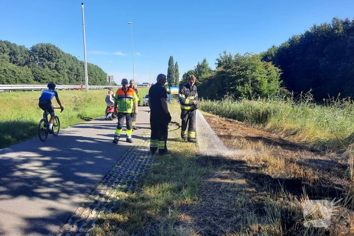 Omstanders doven bermbrand met kleed