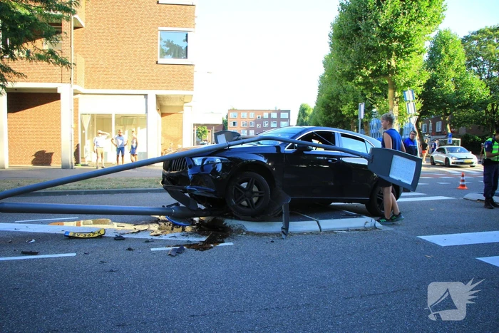 Personenauto uit de bocht, lantaarnpaal geraakt