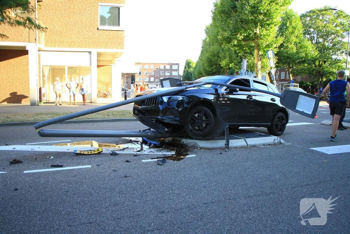 Personenauto uit de bocht, lantaarnpaal geraakt