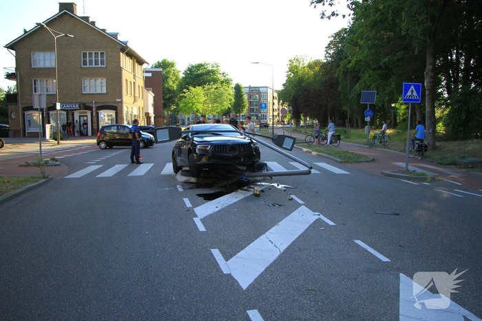 Personenauto uit de bocht, lantaarnpaal geraakt
