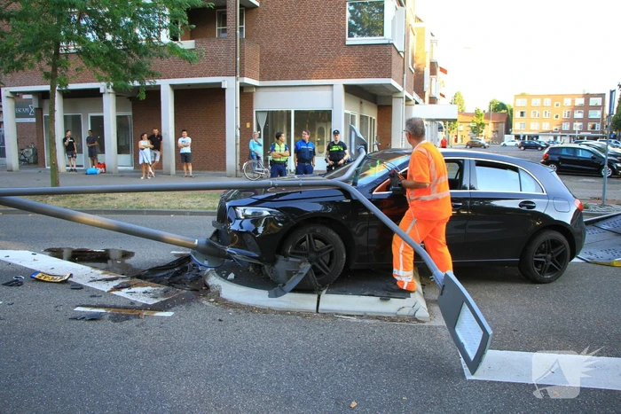 Personenauto uit de bocht, lantaarnpaal geraakt