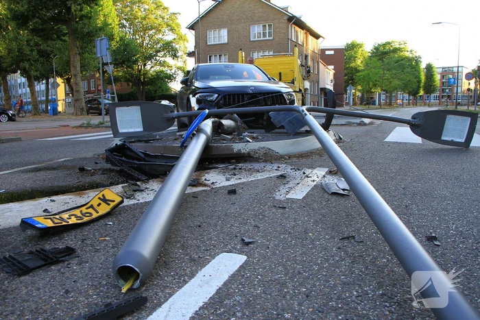 Personenauto uit de bocht, lantaarnpaal geraakt