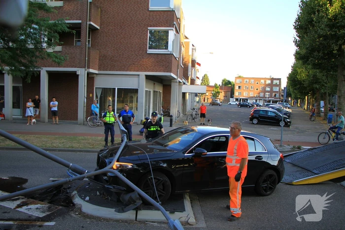 Personenauto uit de bocht, lantaarnpaal geraakt