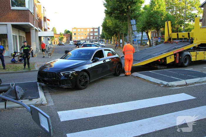 Personenauto uit de bocht, lantaarnpaal geraakt