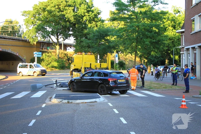 Personenauto uit de bocht, lantaarnpaal geraakt