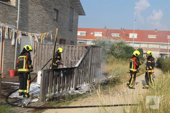 Schutting van woning vat vlam