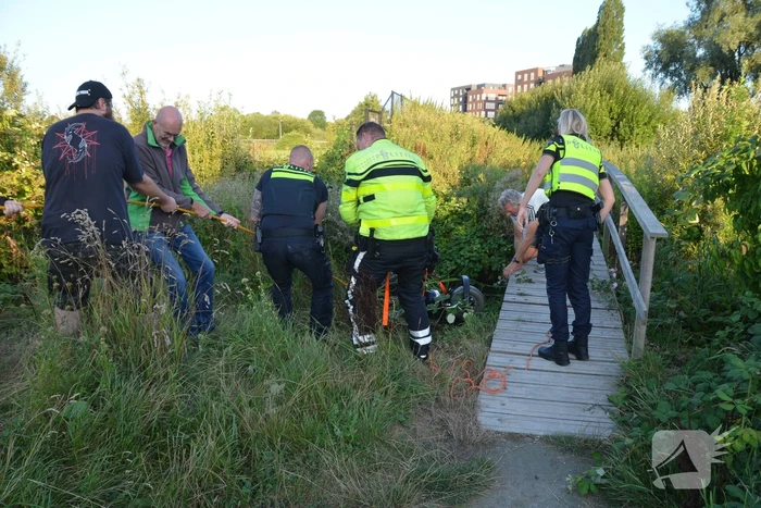 Man op scootmobiel rijdt vanaf brug het water in