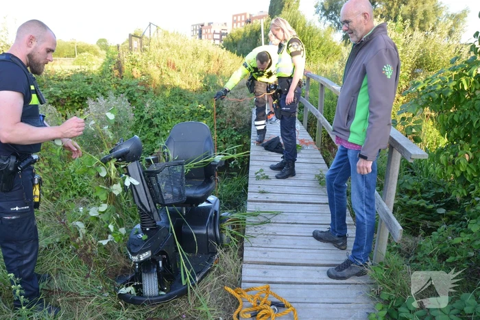 Man op scootmobiel rijdt vanaf brug het water in