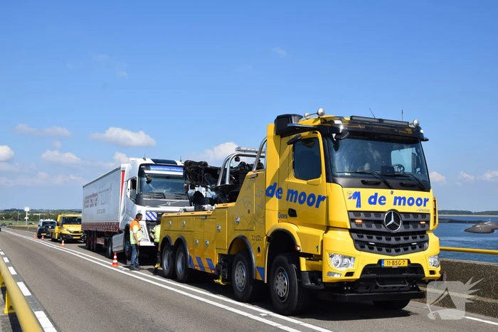 Vrachtwagen schampt wand Zeelandbrug na klapband