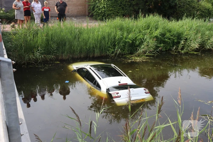 Auto raakt te water naast brug