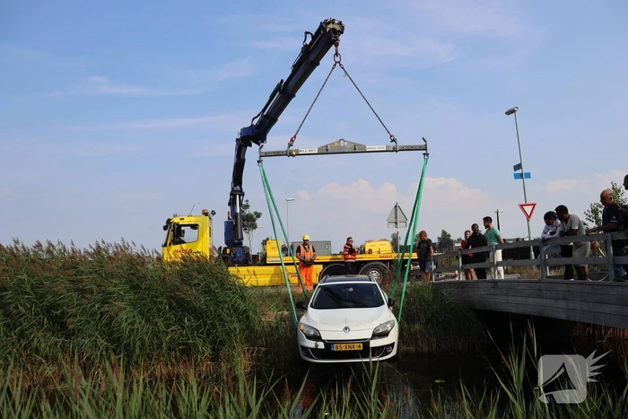 Auto raakt te water naast brug