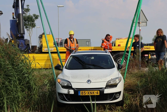 Auto raakt te water naast brug
