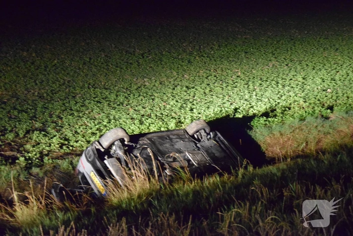 Auto op zijn kop in sloot naast talud