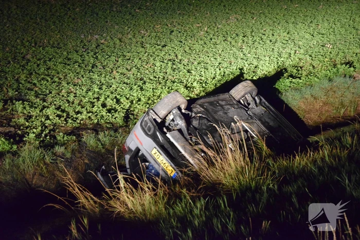 Auto op zijn kop in sloot naast talud