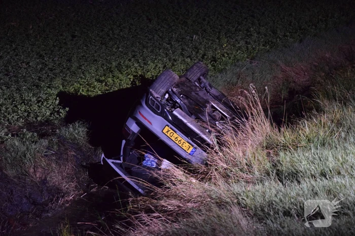 Auto op zijn kop in sloot naast talud