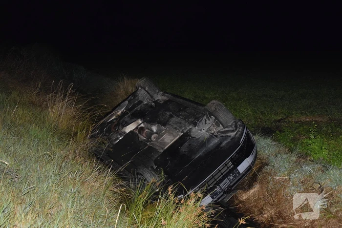 Auto op zijn kop in sloot naast talud