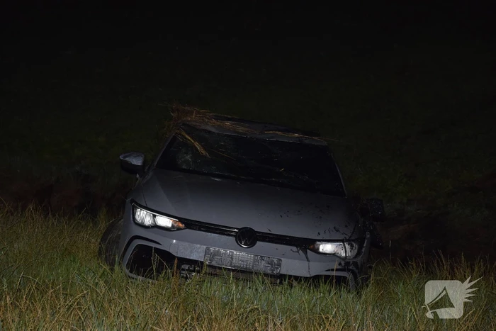 Auto op zijn kop in sloot naast talud