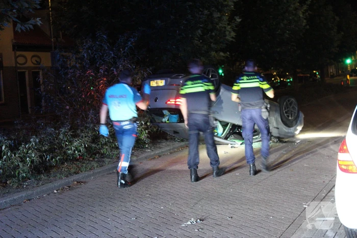 Auto slaat over de kop na botsing tegen stilstaande auto's
