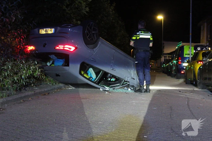 Auto slaat over de kop na botsing tegen stilstaande auto's