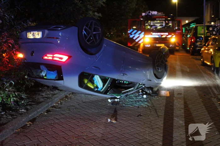 Auto slaat over de kop na botsing tegen stilstaande auto's