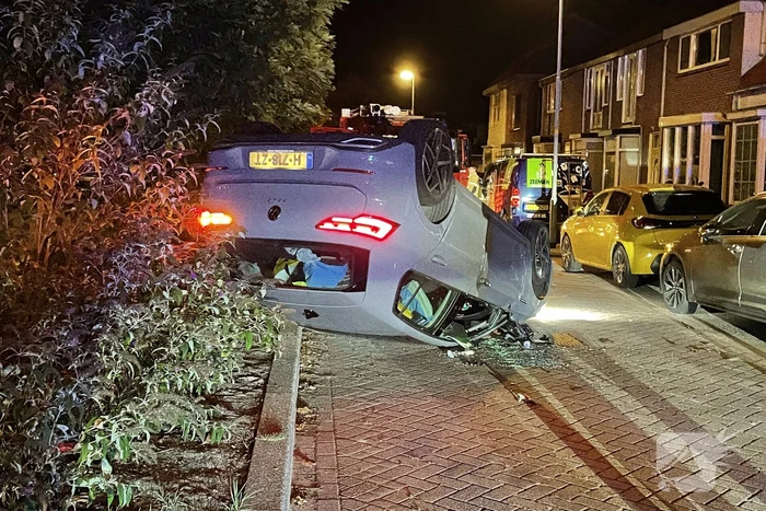 Auto slaat over de kop na botsing tegen stilstaande auto's