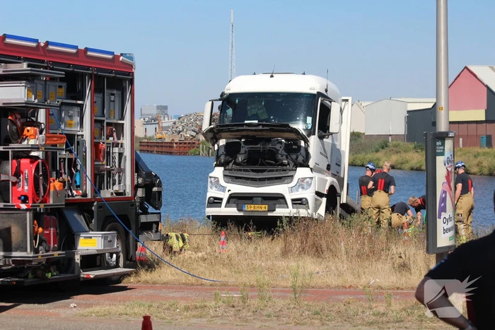 Vrachtwagen hangt gevaarlijk over de waterkant