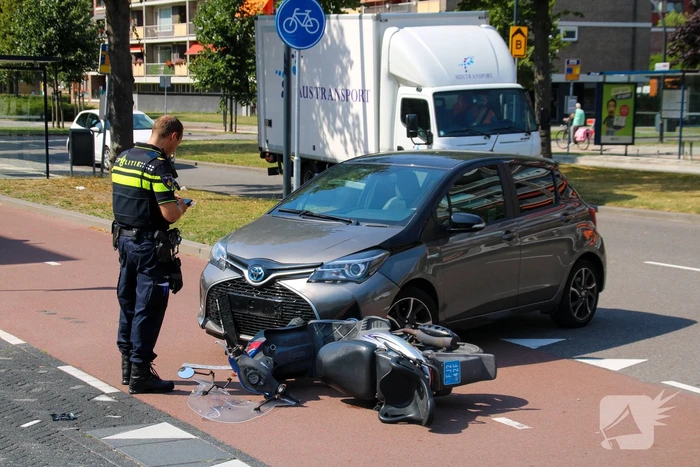 Afslaande automobilist ziet scooterrijder over het hoofd