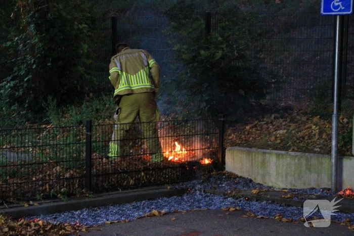 Bladeren vliegen in brand op parkeerterrein