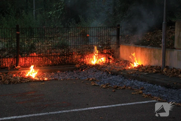 Bladeren vliegen in brand op parkeerterrein