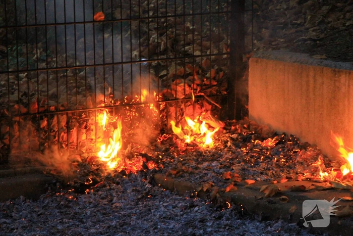 Bladeren vliegen in brand op parkeerterrein