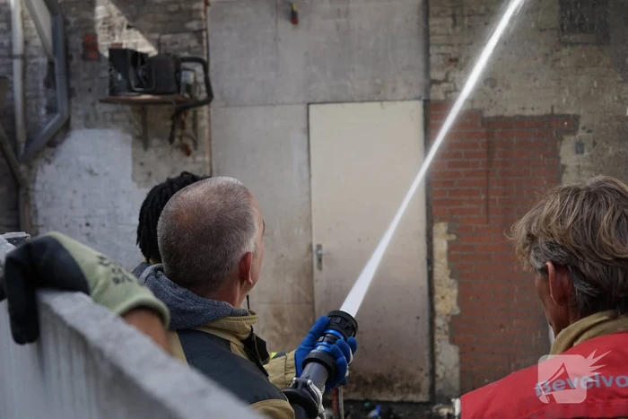 Hoop rommel tegen gevel in brand