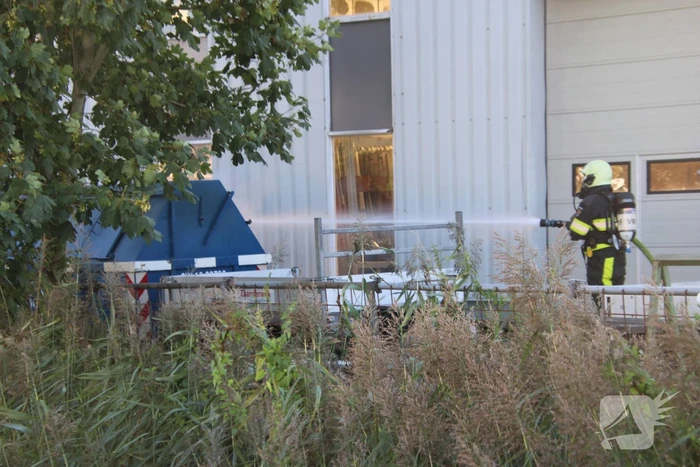 Afvalcontainer met hout in brand