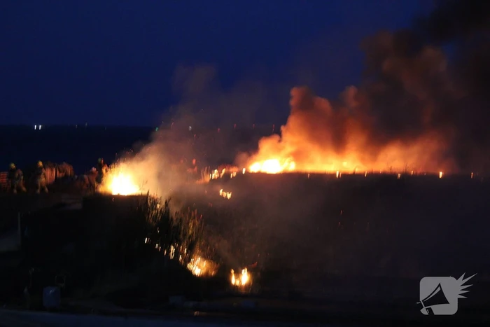 Groot stuk dijk in brand