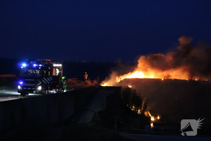 Groot stuk dijk in brand