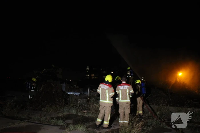 Groot stuk dijk in brand