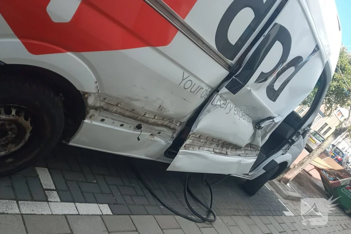 Pakketbezorger botst tegen bouwcontainer en knalt tegen woning