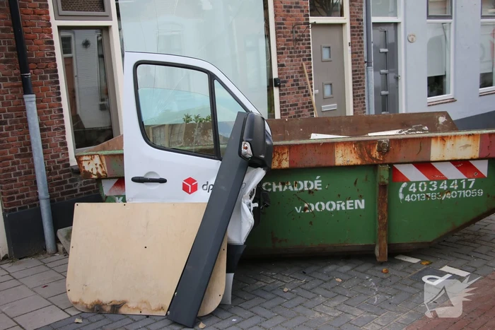 Pakketbezorger botst tegen bouwcontainer en knalt tegen woning