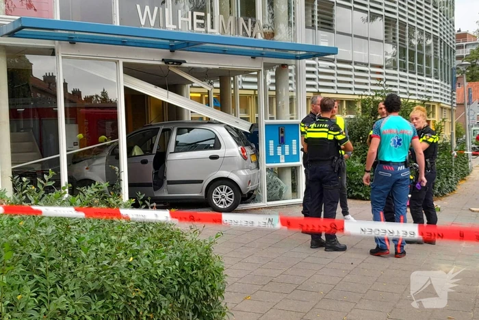 Bestuurster ramt met auto entree flatgebouw
