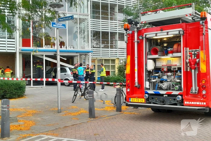 Bestuurster ramt met auto entree flatgebouw
