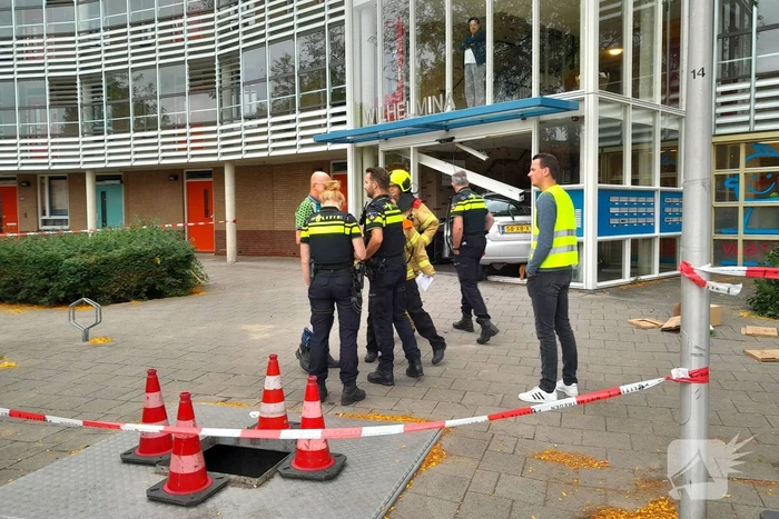 Bestuurster ramt met auto entree flatgebouw