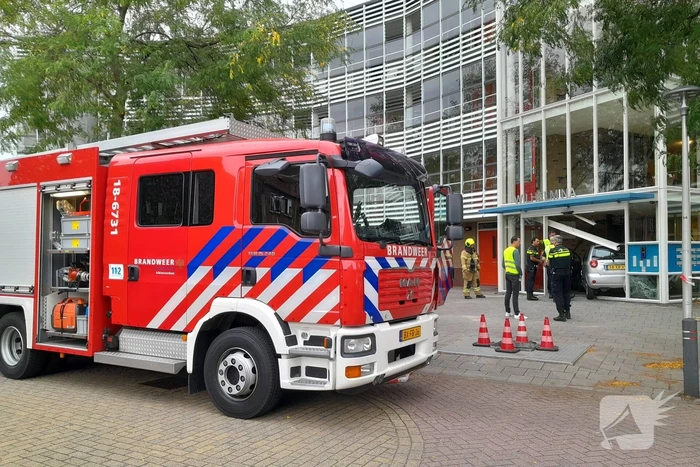 Bestuurster ramt met auto entree flatgebouw