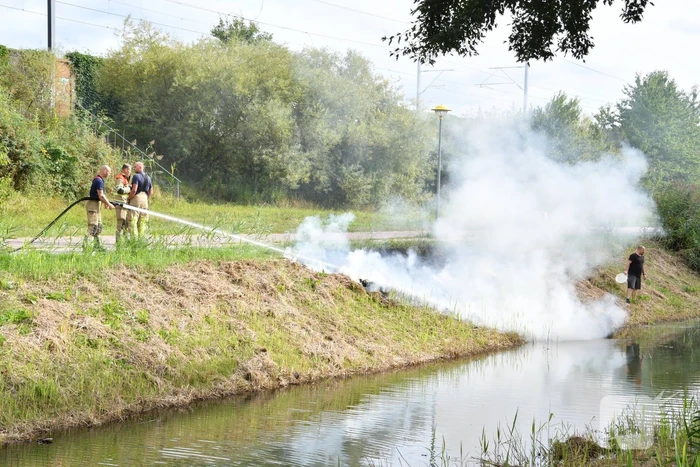 Man helpt brand blussen met emmers water