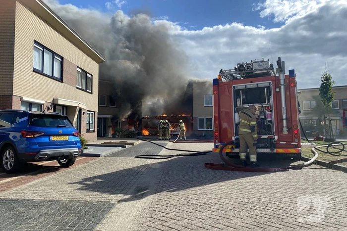 Enorme vlammen en rookwolken bij woningbrand