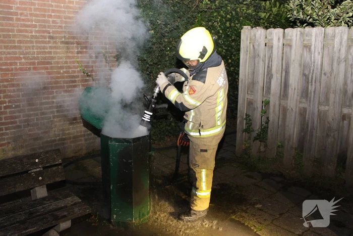 Brandweer blust brand in prullenbak