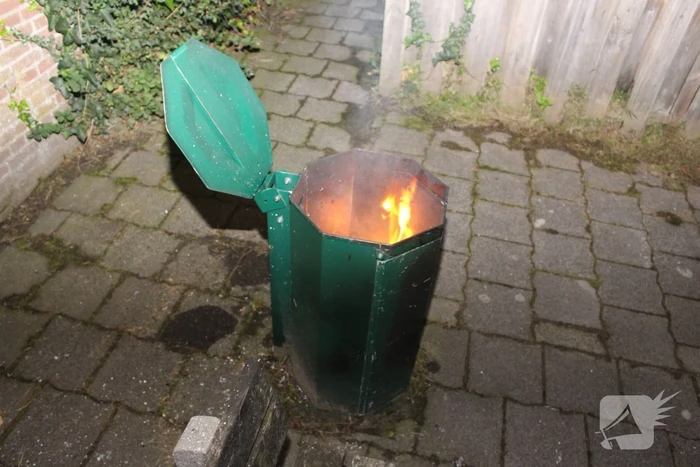 Brandweer blust brand in prullenbak