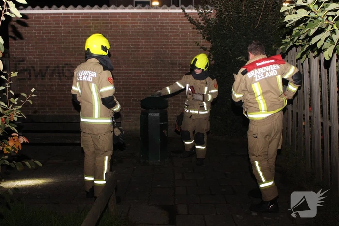 Brandweer blust brand in prullenbak